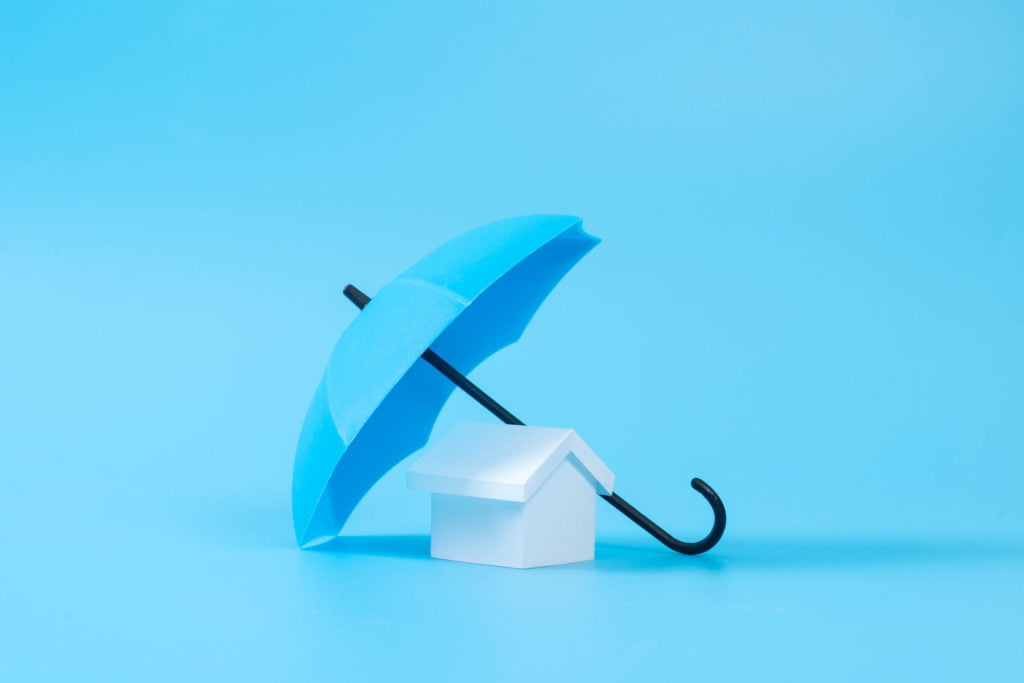 a blue umbrella covering a white house with a blue background