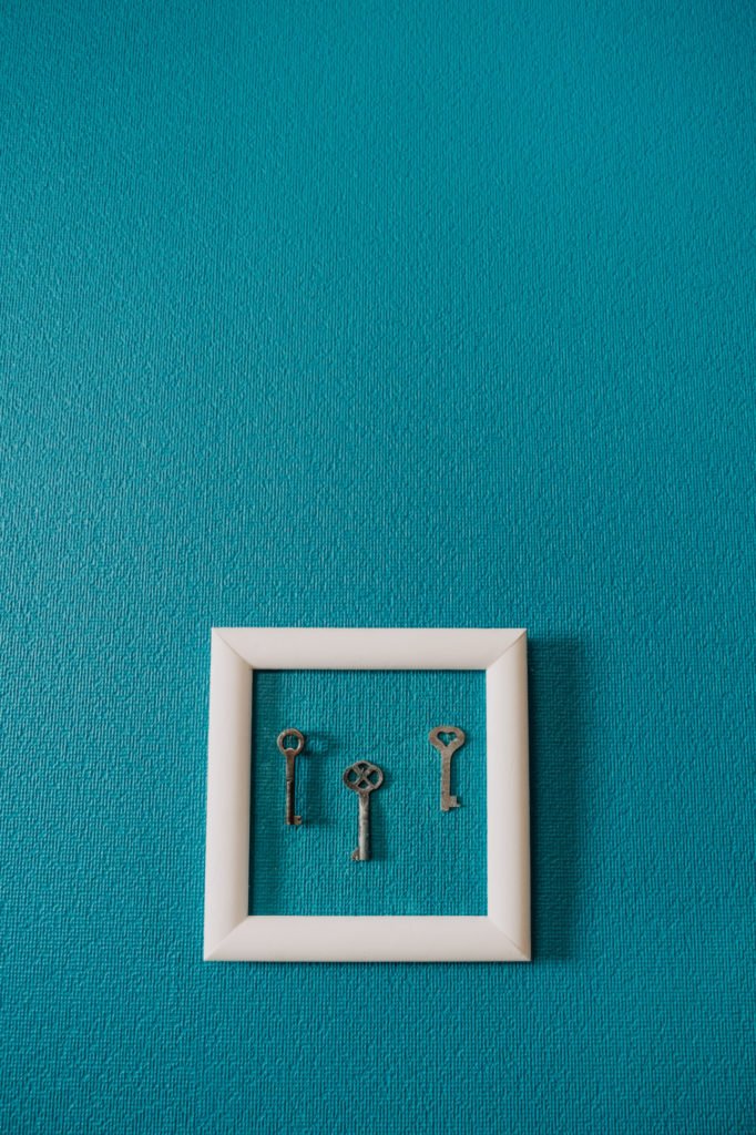 Key in frame on blue wall backgroung. Key new home, homeownership, keys to the house, buying home.