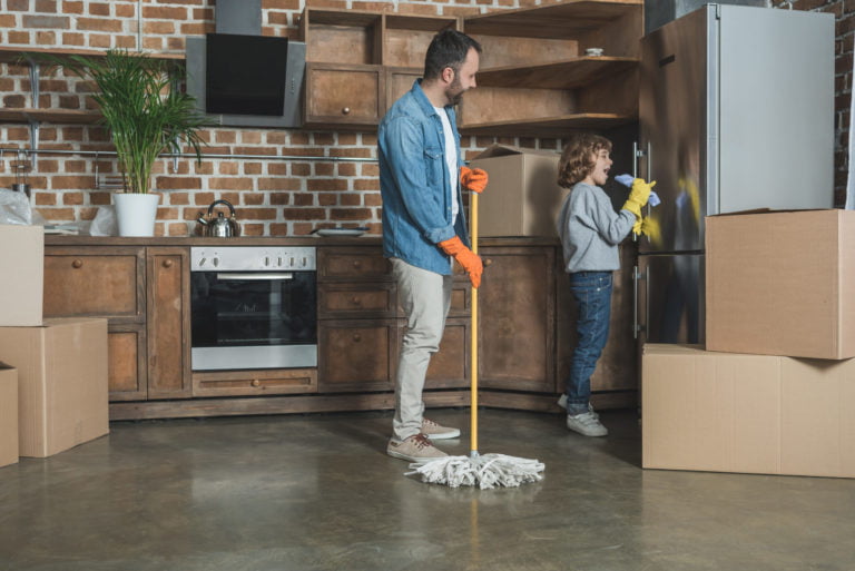 happy father and son in rubber gloves cleaning new apartment after relocation