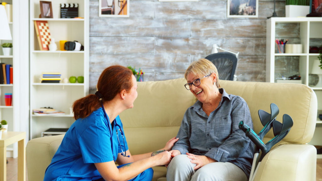 Female nurse talking with old woman with alzheimer